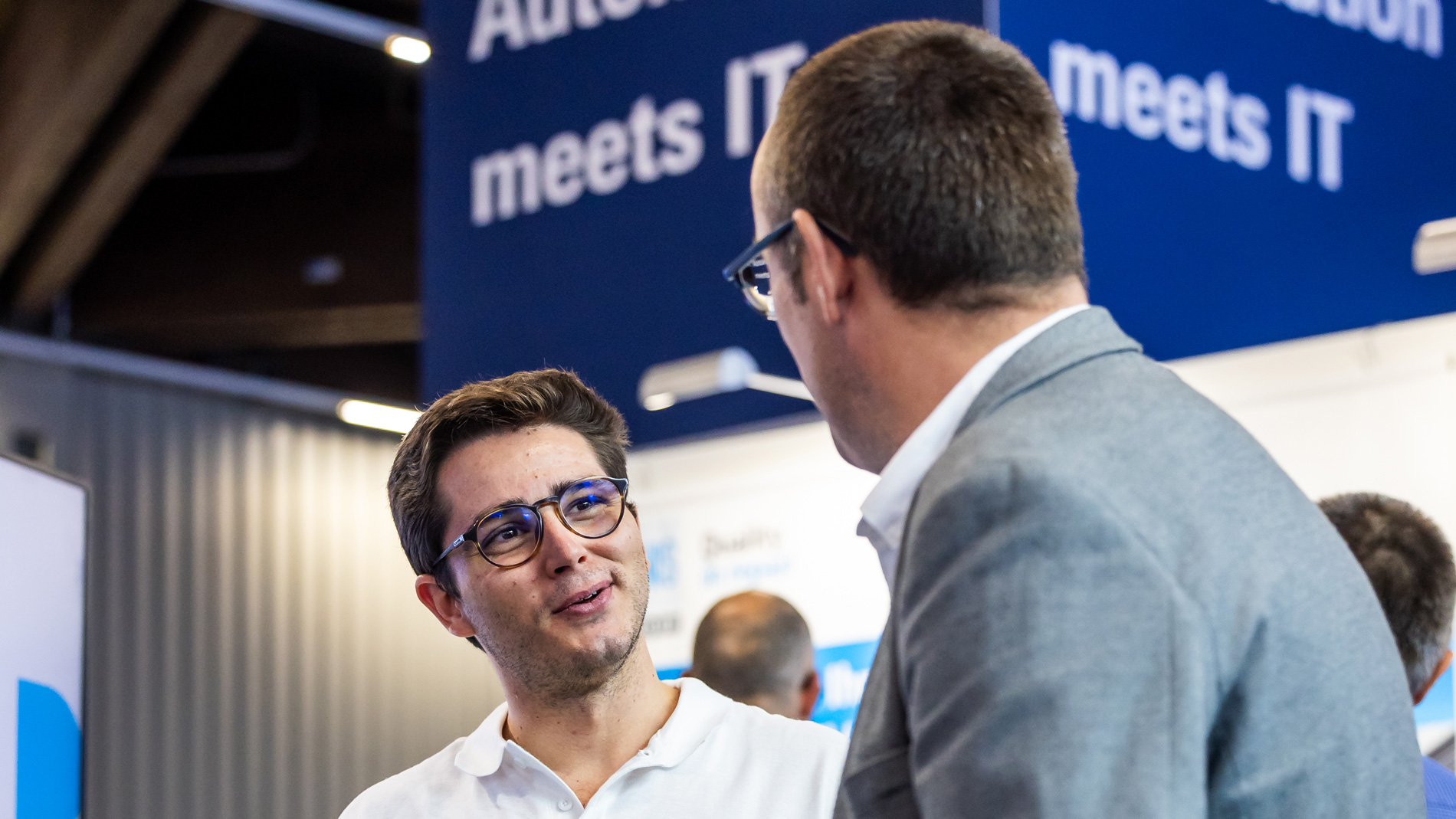 Zwei Fachbesucher unterhalten sich auf dem Gemeinschaftsstand ‚Automation meets IT‘ der SPS.