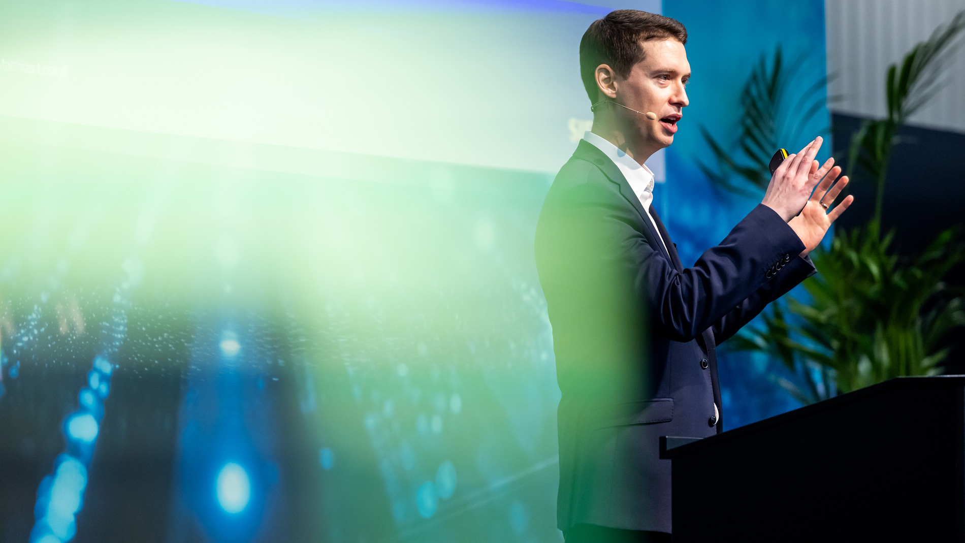 Vortragende Person präsentiert auf einer Konferenzbühne Inhalte zu digitalen Technologien und industriellen Innovationen.
