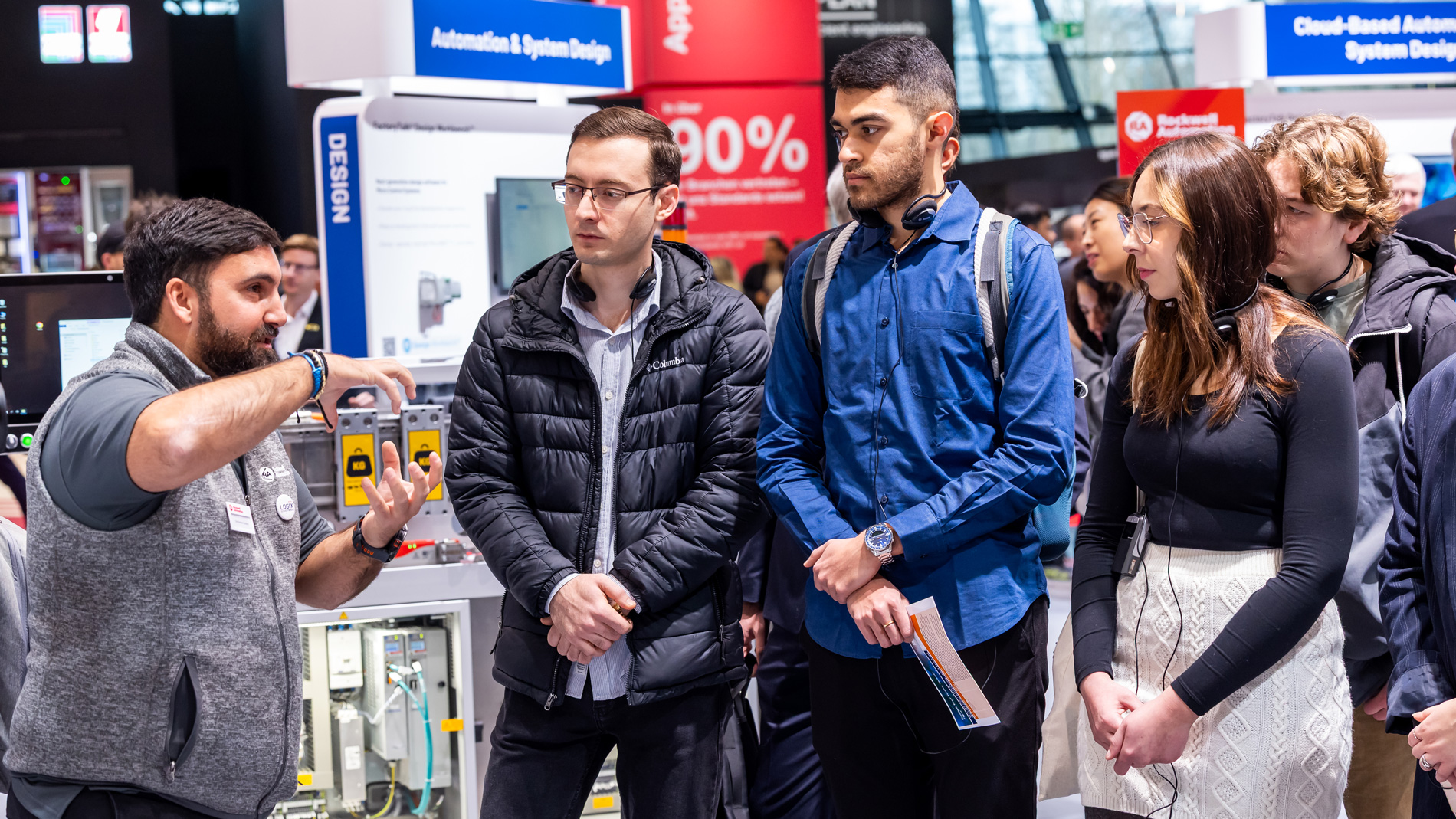 Young trade show visitors follow an expert during a guided tour at the SPS and learn about automation solutions.