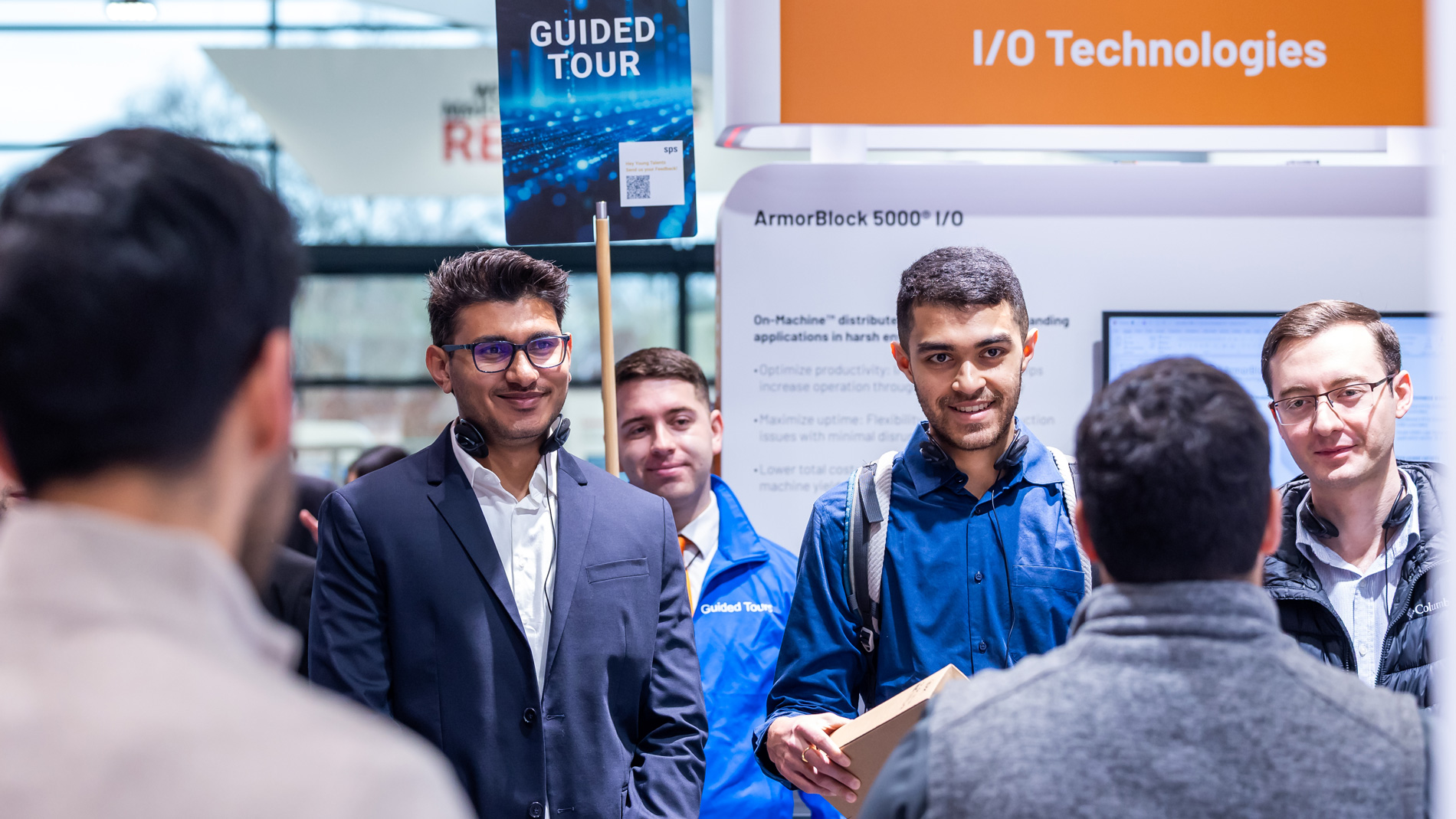 Participants of a guided tour at the SPS exchange ideas with exhibitors about automation technologies.